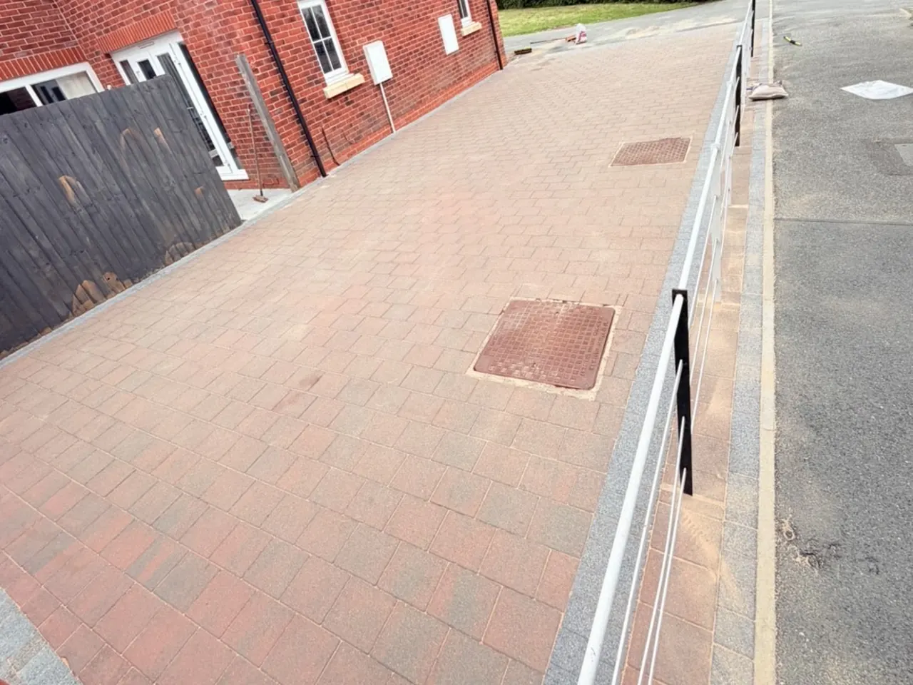 The same block paving path after cleaning, weeds cleared and the red and buff blocks visible again.