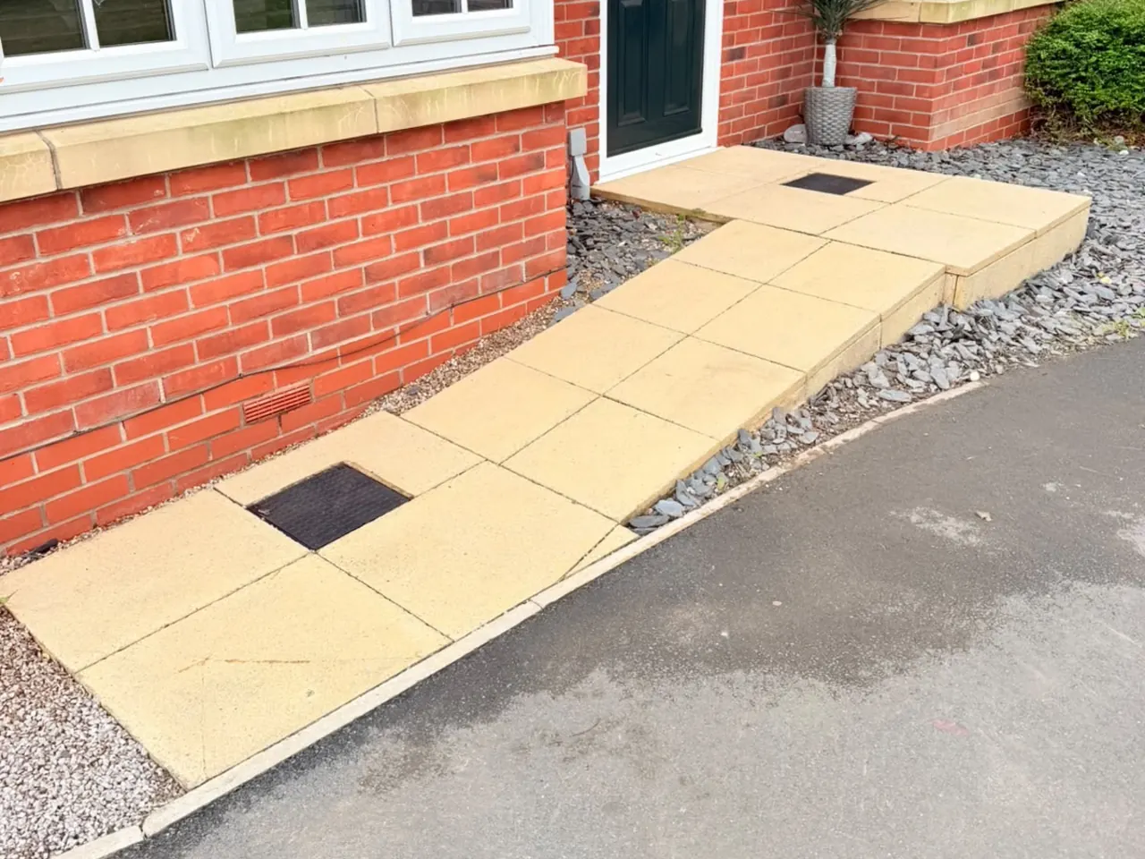 The same path after cleaning, the rust staining gone and the slabs a light buff colour.