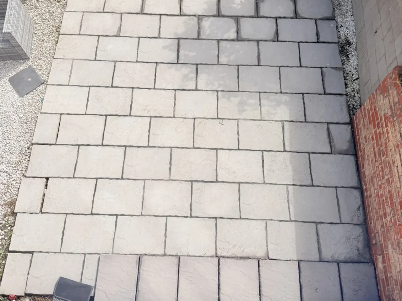 The same rear patio after cleaning, the paving an even warm buff and the joints clear.
